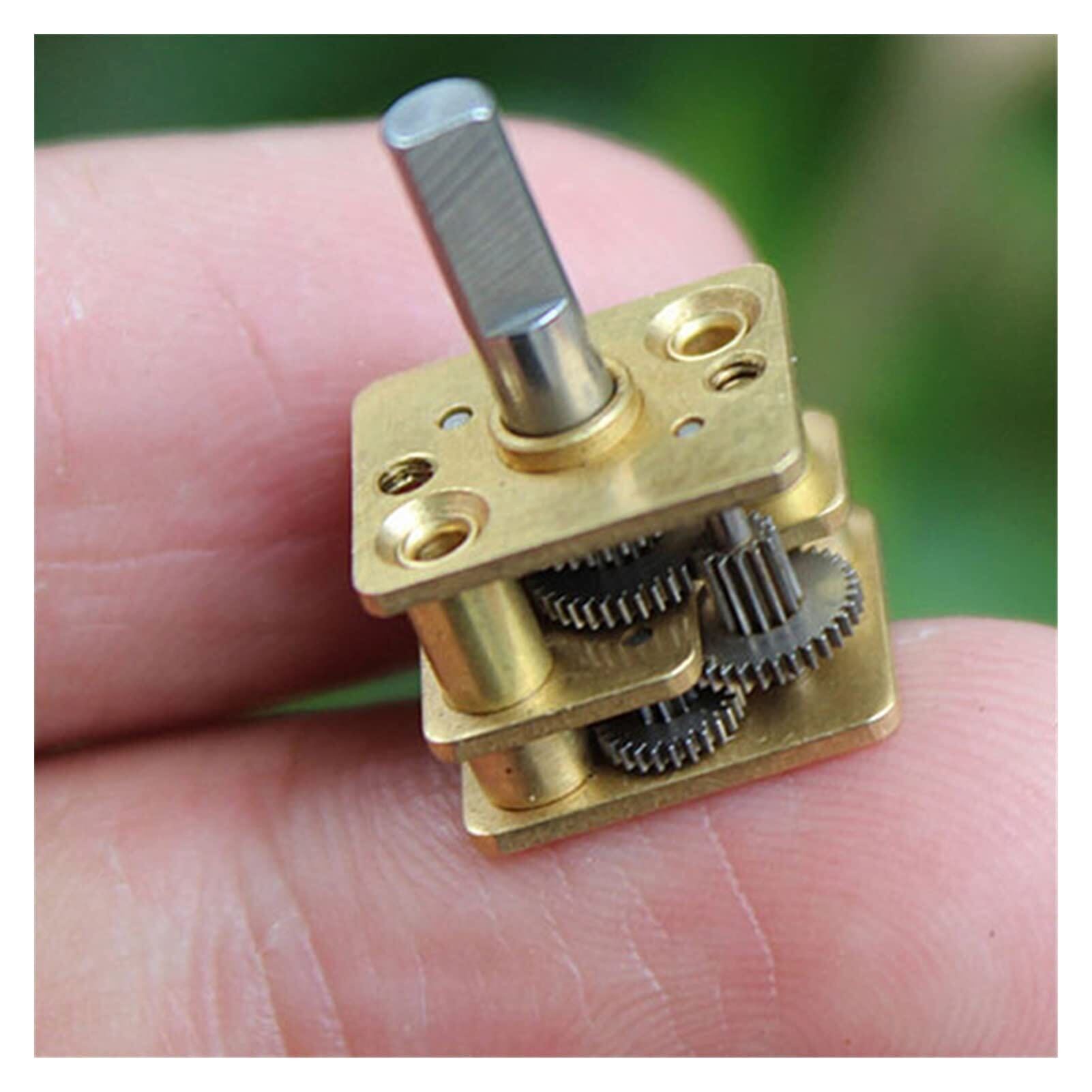 A tiny high-ratio gearbox sitting on a fingertip, showing how small the gear teeth are.